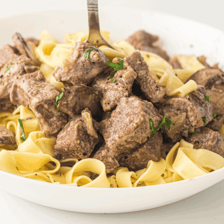 Creamy Beef Stroganoff served over egg noodles, garnished with fresh parsley.