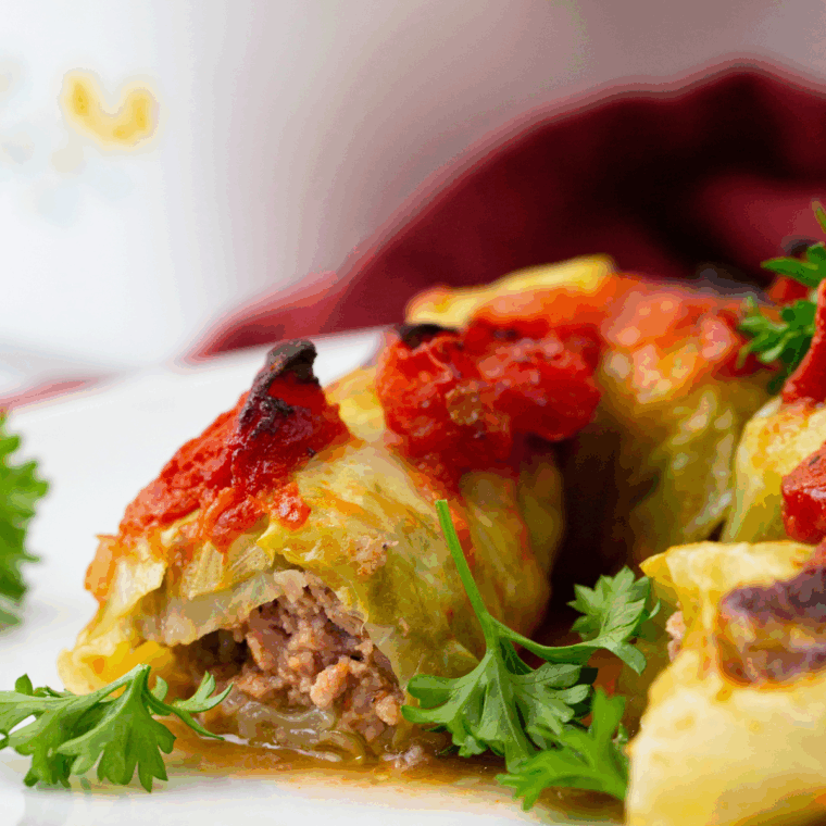 Homemade Ina Garten stuffed cabbage rolls filled with beef and rice, simmered in tomato sauce and topped with fresh parsley.