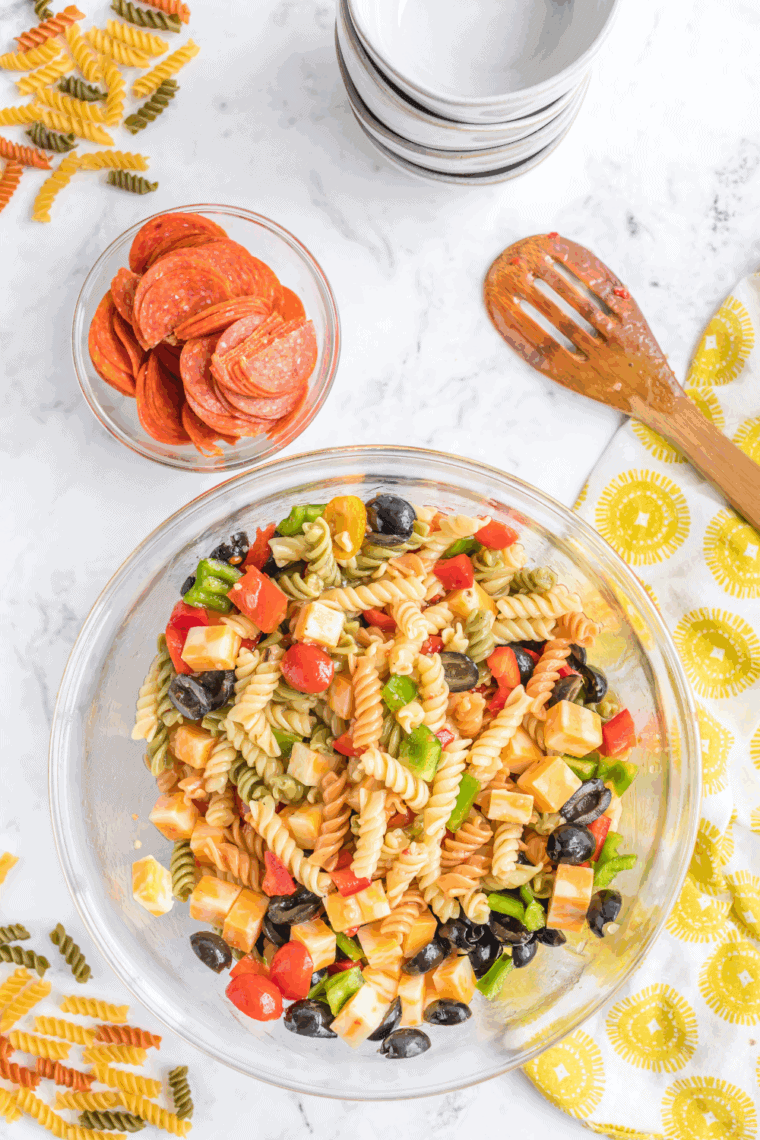 Bowl of creamy Jason’s Deli pasta salad with rotini, cheddar cheese, bell peppers, celery, and fresh herbs.