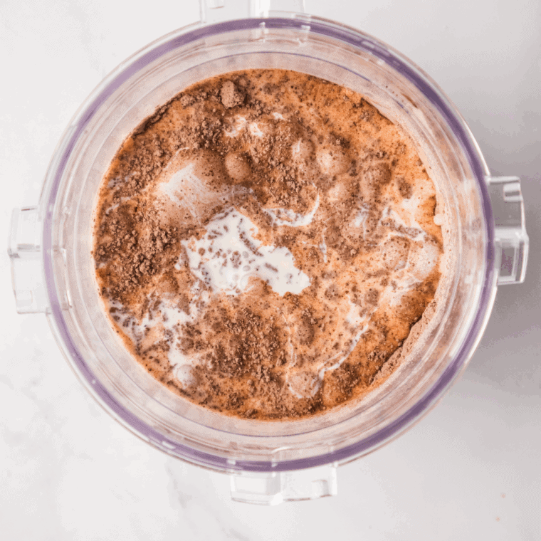 Whisking heavy cream, milk, sugar, cocoa powder, and vanilla extract together to make smooth chocolate ice cream base.