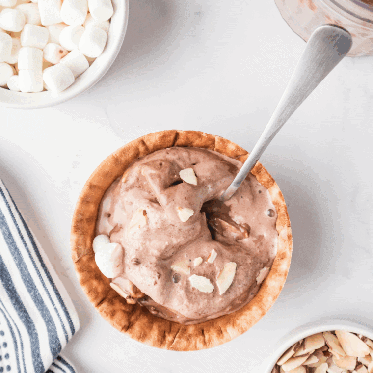 Bowl of homemade Rocky Road ice cream with chocolate chunks, marshmallows, and chopped almonds.