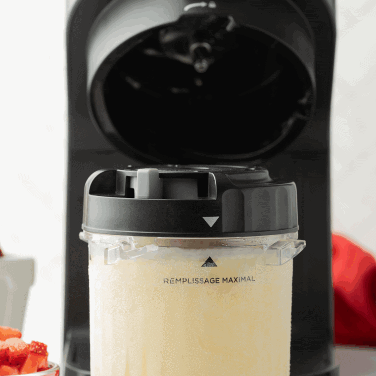 Ninja Creami machine with frozen pint inserted, processing ice cream to creamy texture.