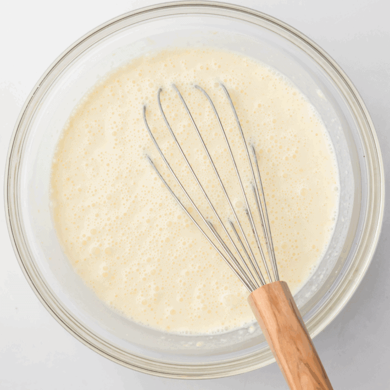 Whisking heavy cream, whole milk, sugar, and vanilla in a bowl until smooth.