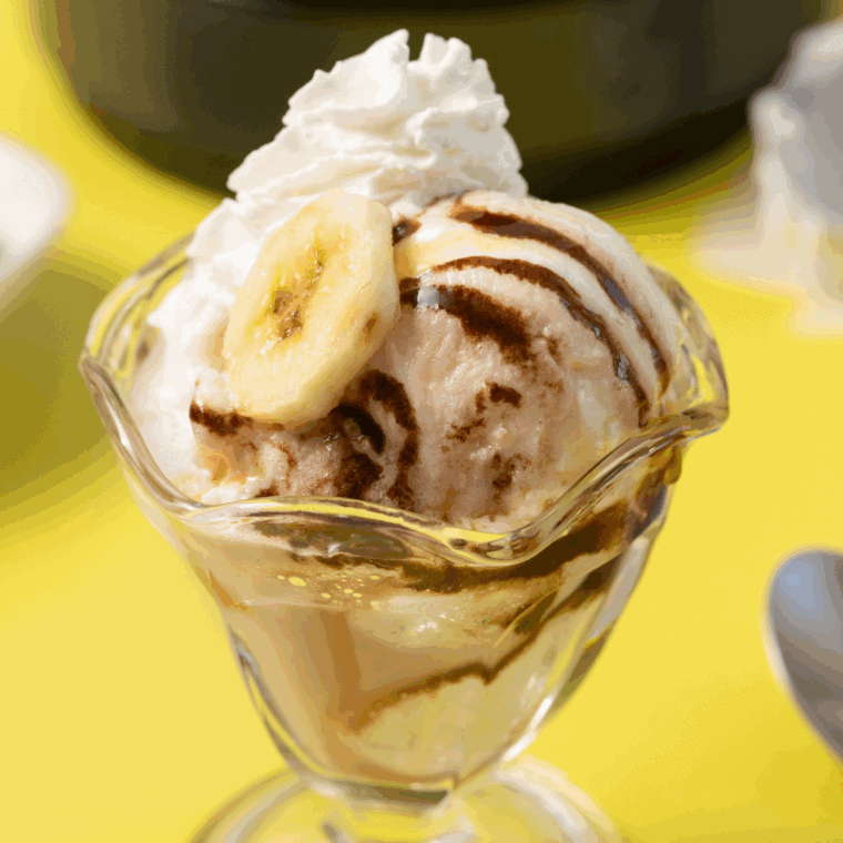 Homemade Ninja Creami Pralines n’ Cream ice cream with praline pieces and caramel swirls in a bowl.