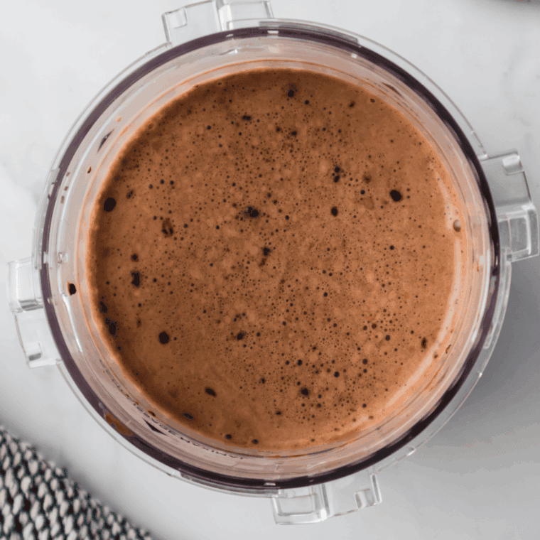 Whisking heavy cream, milk, sugar, cocoa powder, malted milk powder, and vanilla in a bowl until smooth.