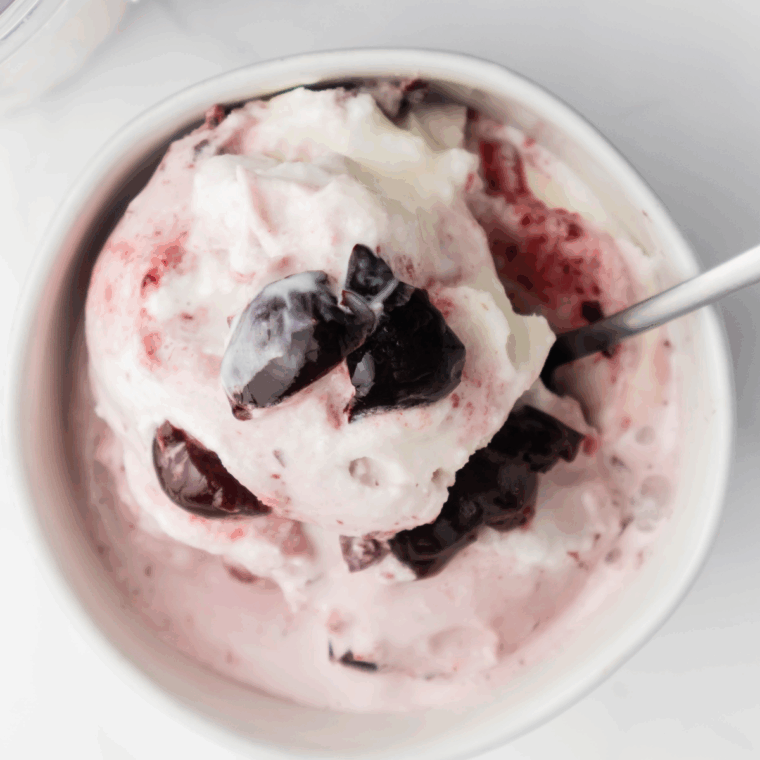 Creamy Ninja Creami Copycat Baskin Robbins Cherry Jubilee ice cream topped with juicy cherries in a bowl.