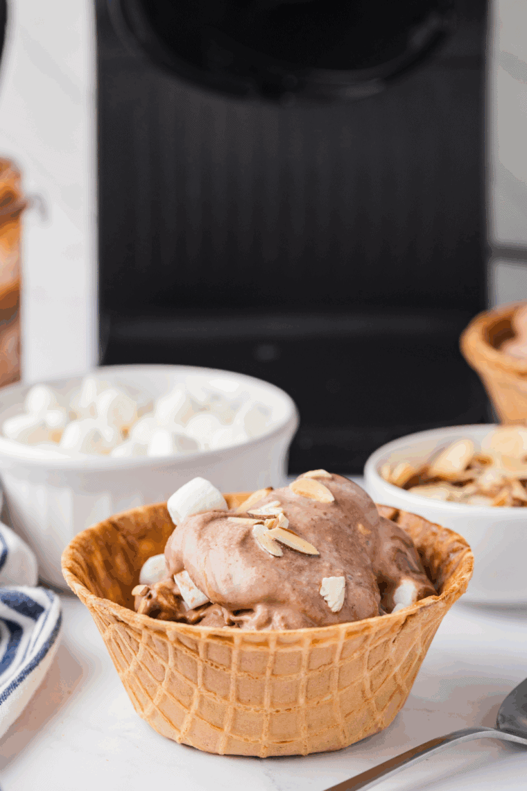 Bowl of homemade Rocky Road ice cream with chocolate chunks, marshmallows, and almonds.