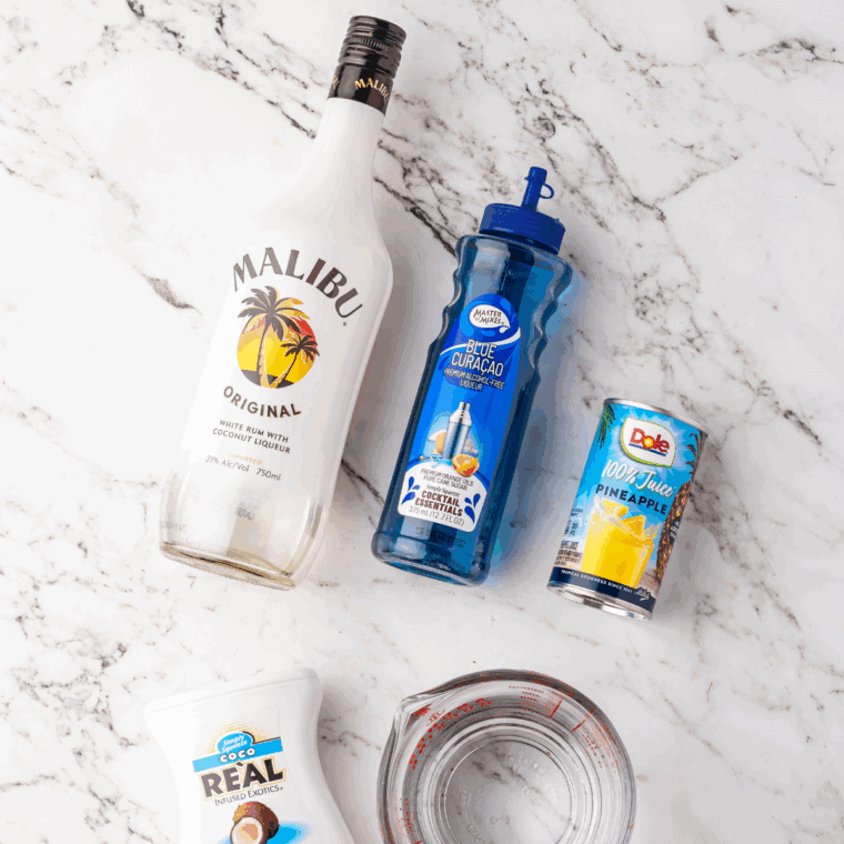 Ingredients needed for Ninja Slushi Easy Blue Hawaiian Cocktail Recipe on kitchen table.