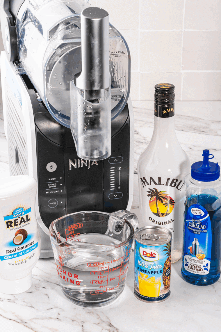 Ingredients for Ninja Slushi Easy Blue Hawaiian Cocktail Recipe on kitchen table. about ready to be poured in.
