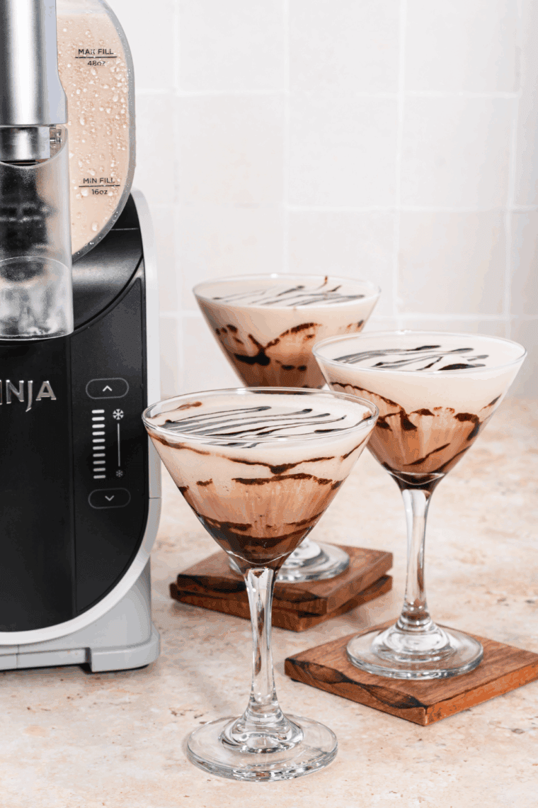 Glass of Ninja Slushi Frozen Chocolate Martini topped with chocolate drizzle and served chilled.
