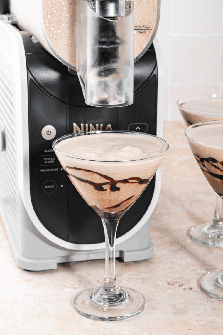 Chilled Ninja Slushi Frozen Chocolate Martini in a martini glass with chocolate drizzle and whipped cream.
