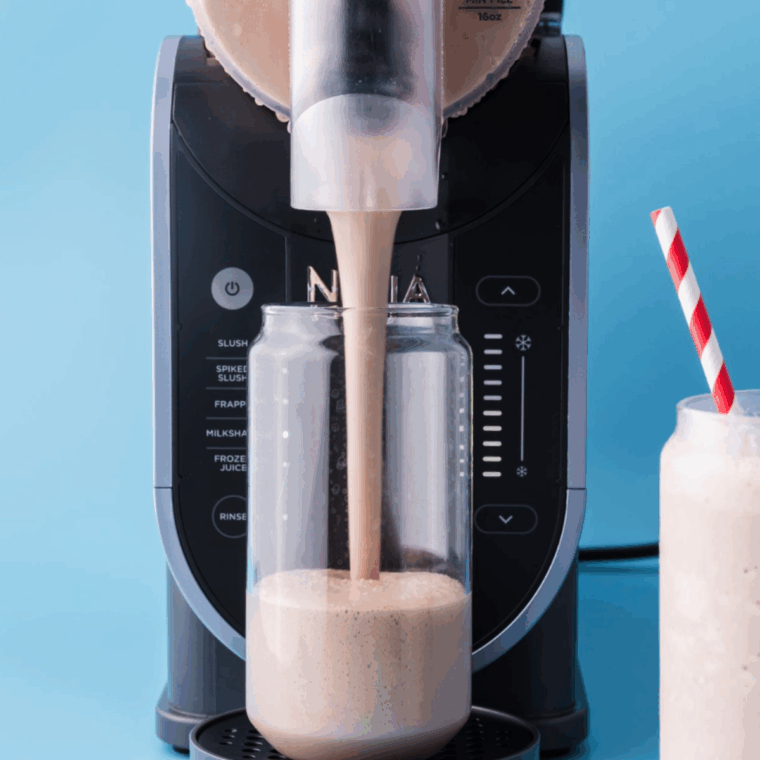 Ninja Slushi Protein Milkshake in a glass, topped with optional peanut butter cups, creamy and frosty.