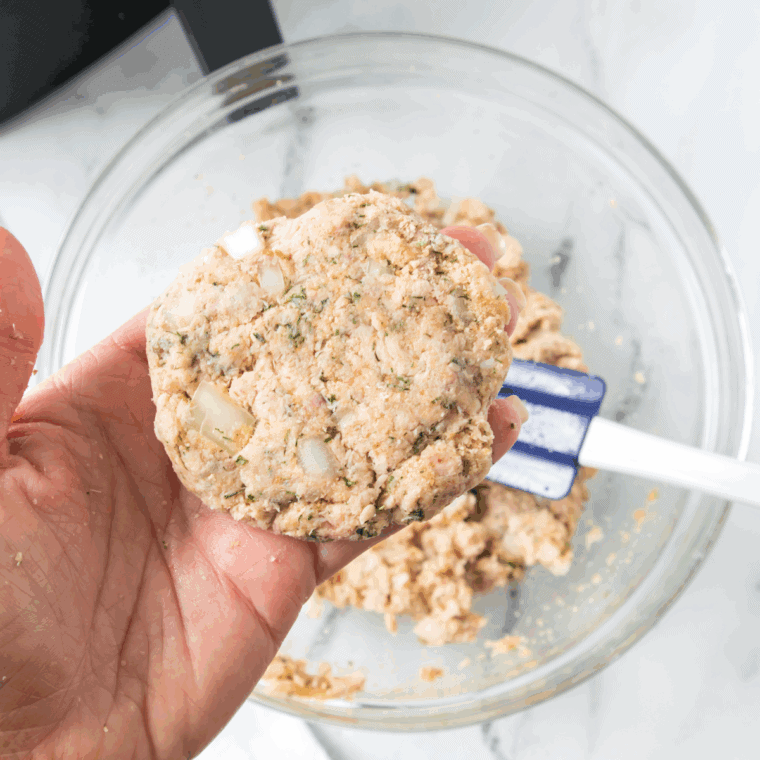 Forming salmon mixture into six evenly sized patties and heating olive oil or butter in a skillet over medium heat.