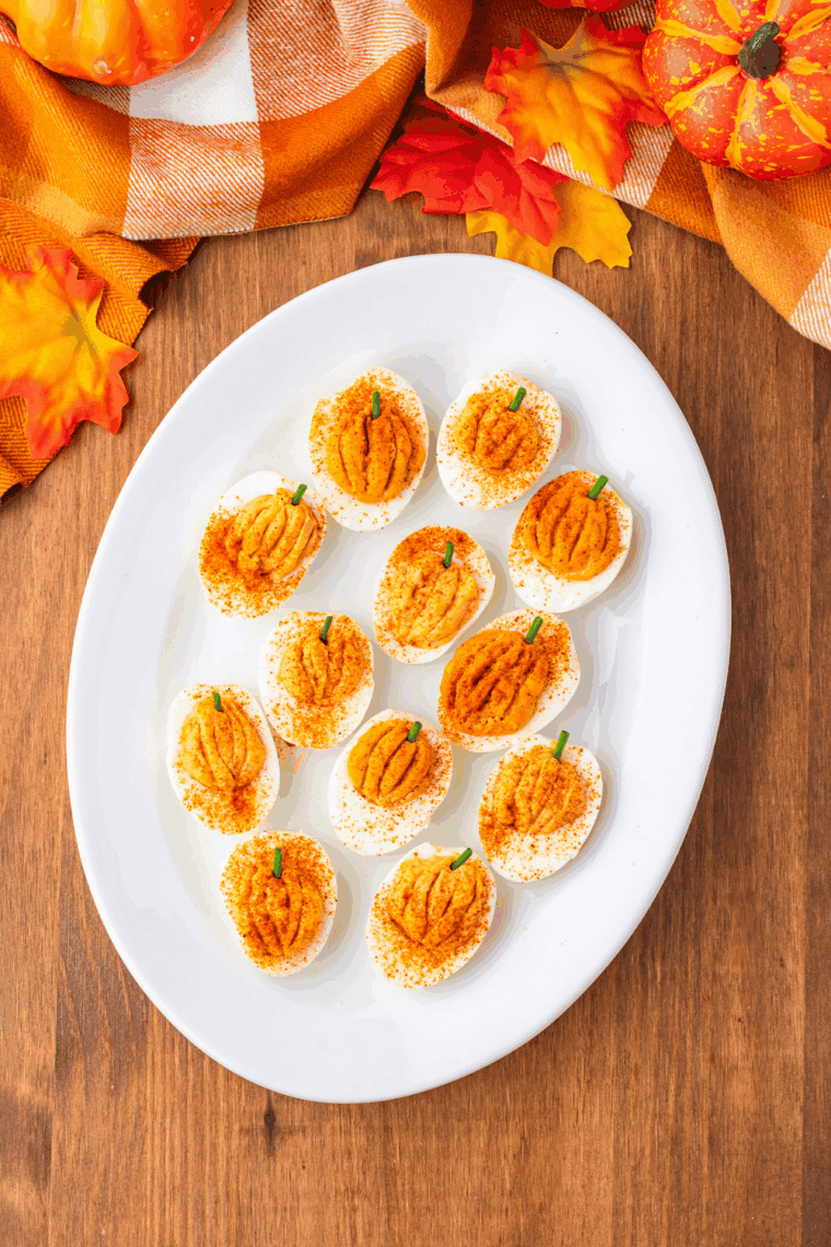 Plate of Pumpkin Deviled Eggs  on kitchen table.