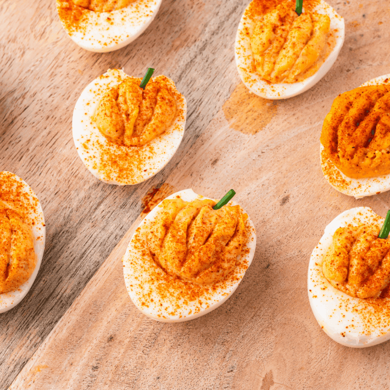 Pumpkin deviled eggs styled like mini pumpkins, perfect for Halloween or Thanksgiving gatherings.