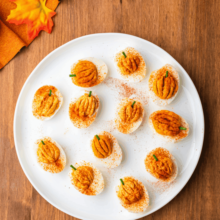 Pumpkin-shaped deviled eggs chilled and served on a platter for Halloween or Thanksgiving.