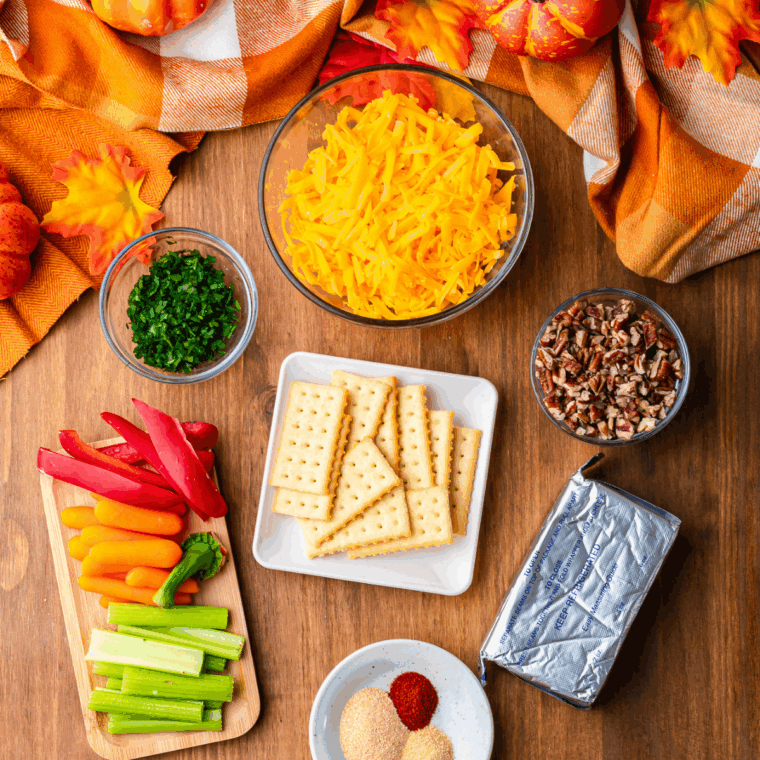 Ingredients needed for Pumpkin Shaped Cheese Ball for Halloween or Thanksgiving on kitchen table.