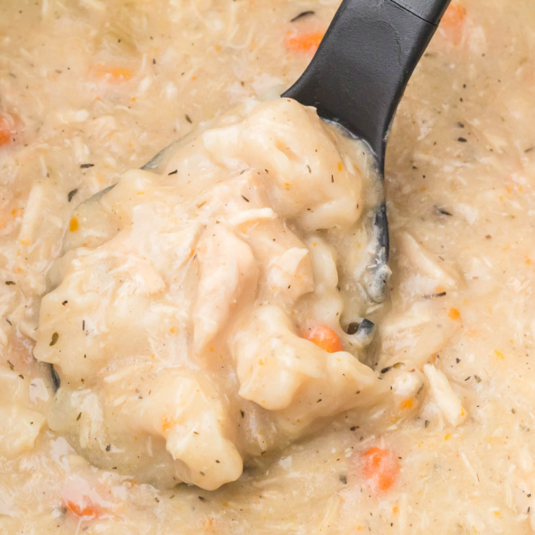Creamy crockpot chicken and dumplings with shredded chicken and fluffy biscuit dumplings in thick gravy.