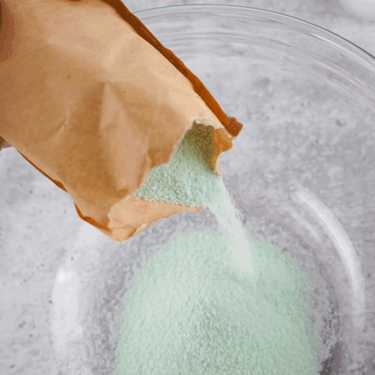 Mixing lime Jello powder with boiling water in a large bowl until fully dissolved.