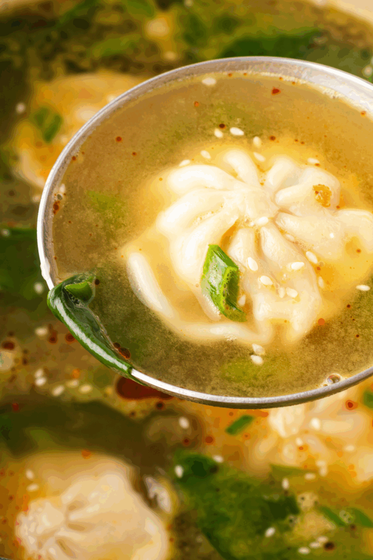 Bowl of Trader Joe’s Famous Wonton Soup with dumplings, sliced carrots, green onions, and fresh lime wedge.