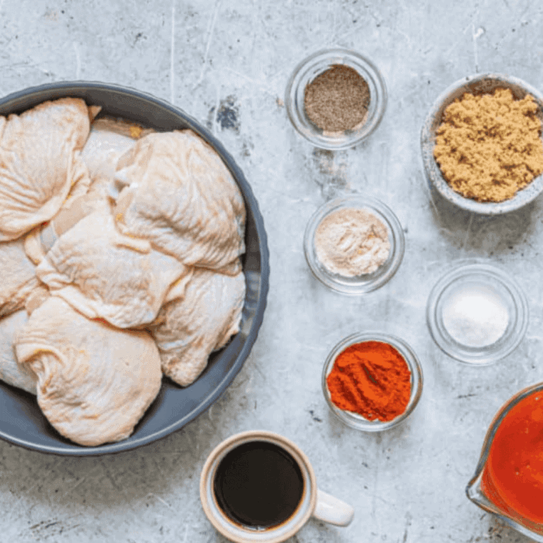 Chicken wings or pieces marinating in a thick, orange-red Buffalo Marinade in a glass bowl, ready to be cooked.
