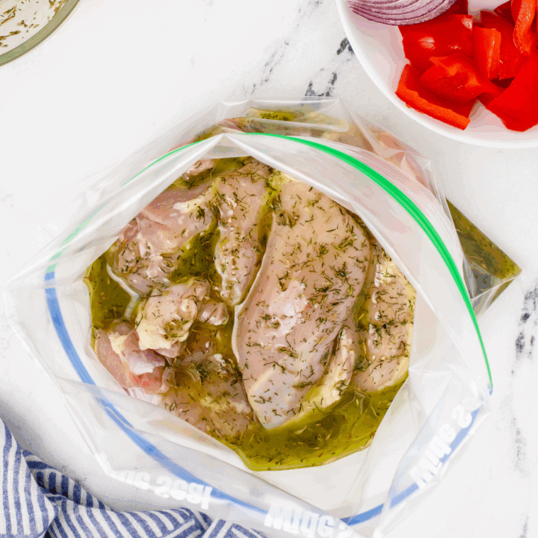 Bowl of Greek yogurt herb marinade with fresh herbs and garlic, ready for chicken