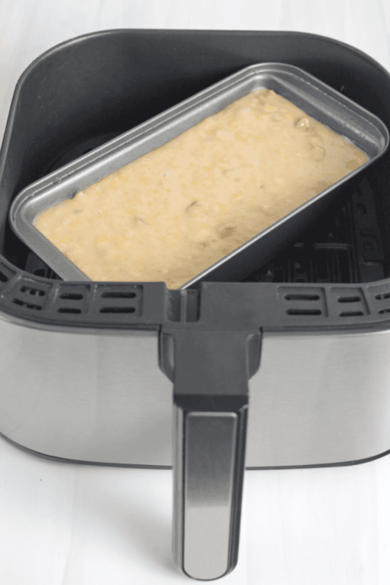 Air fryer releasing smoke from the basket during cooking on a kitchen countertop.