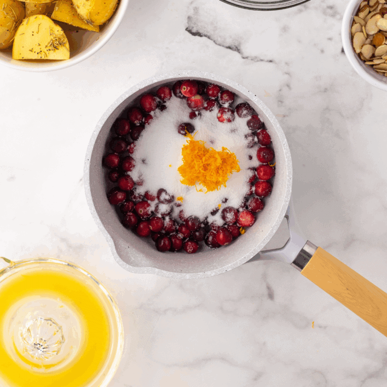 Cranberries and sugar combined in a saucepan, ready to cook.