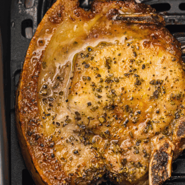 A small white bowl filled with the coarse, dark brown Copycat Kinder&rsquo;s The Blend seasoning mix, showing visible herbs, cracked pepper, and spices.