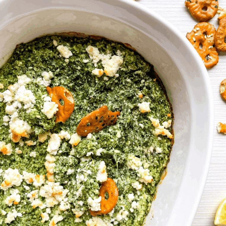 Creamy Spanakopita Dip served in a bowl, topped with crumbled feta and fresh herbs.Select 86 more words to run Humanizer.