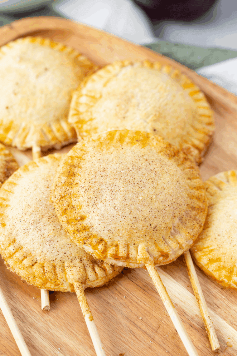Golden air fryer apple pop-tarts drizzled with glaze, served on a plate ready to eat.