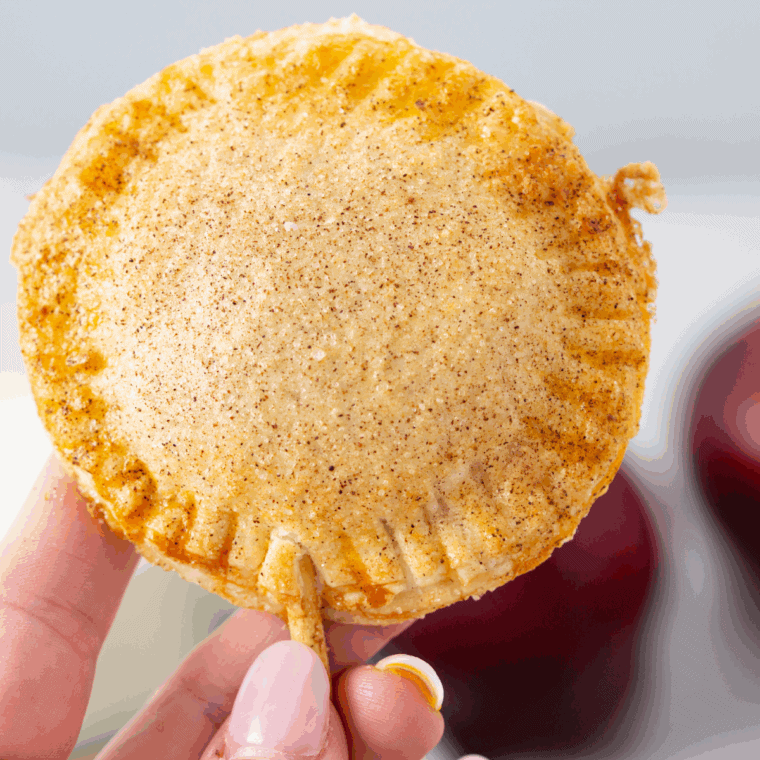 Golden, flaky air fryer apple pop-tarts drizzled with glaze, served on a plate ready to eat.