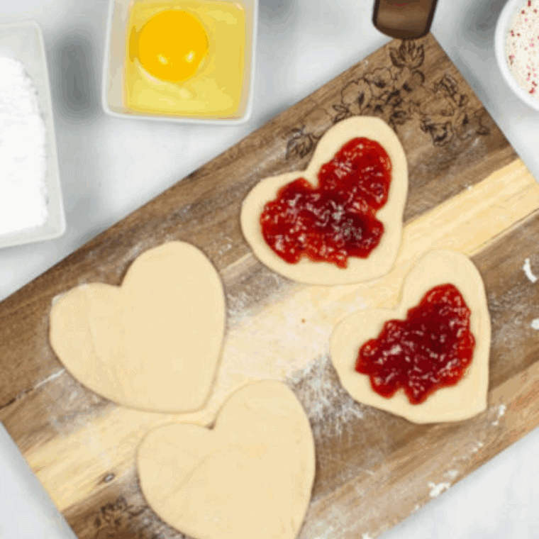 Add the Filling: Spoonful of cranberry jam placed in the center of each pie crust rectangle, leaving edges clear.