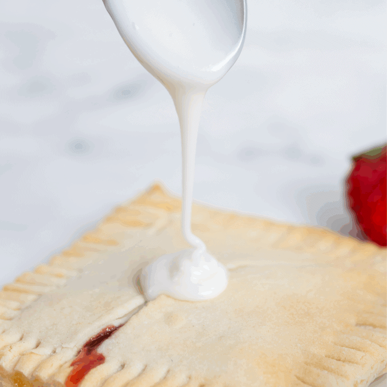 Glaze and Decorate: Powdered sugar glaze drizzled over warm raspberry pop-tarts with optional sprinkles.