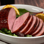 Sliced, fully cooked Amish ham with a sweet, sticky glaze ready for carving.