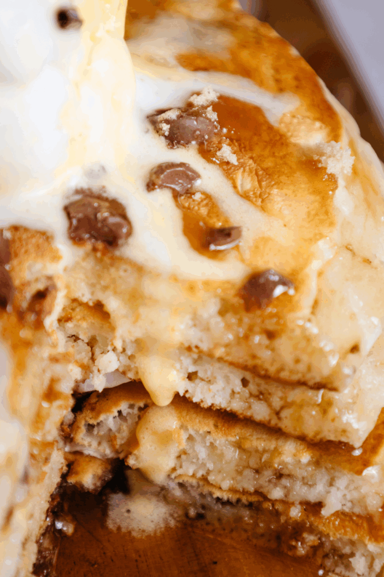 Stack of golden, fluffy Denny’s-style pancakes served with syrup and butter.