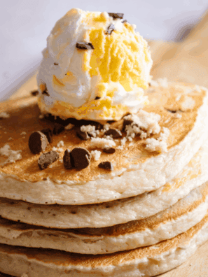 Stack of fluffy golden Denny’s-style pancakes on a plate, ready to serve.