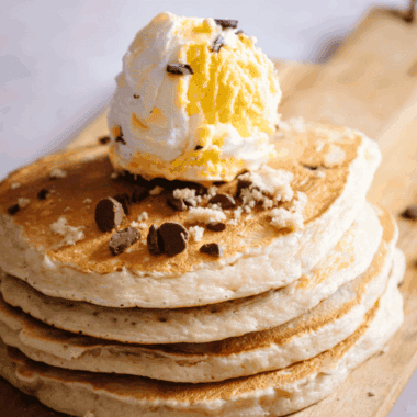 Stack of fluffy golden Denny’s-style pancakes on a plate, ready to serve.