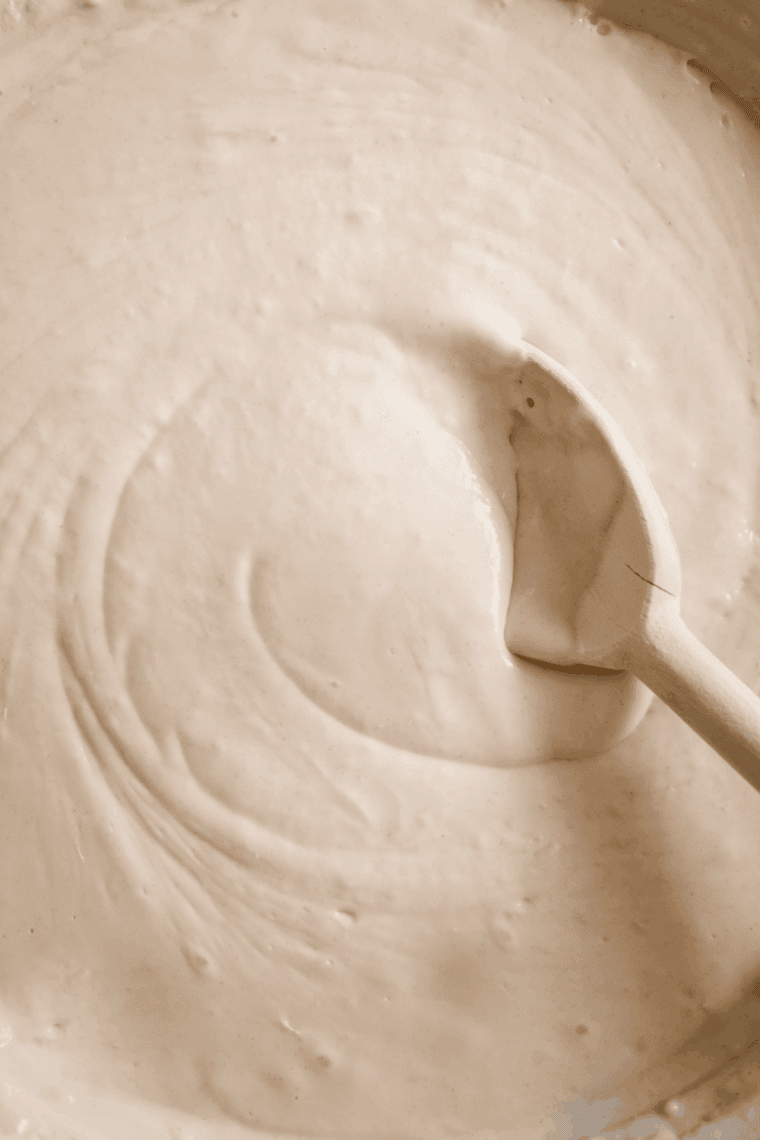 Pouring wet ingredients into dry ingredients, gently mixing until just combined.