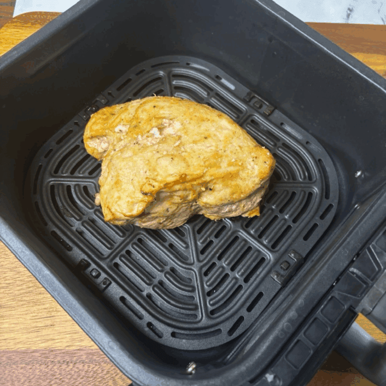 Cooking the frozen turkey breast in the air fryer basket.