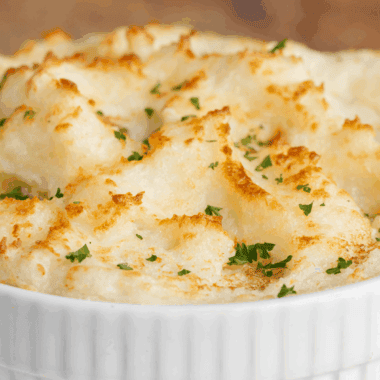 Large bowl of fluffy, rich, and creamy Golden Corral Mashed Potatoes topped with a pat of melting butter.