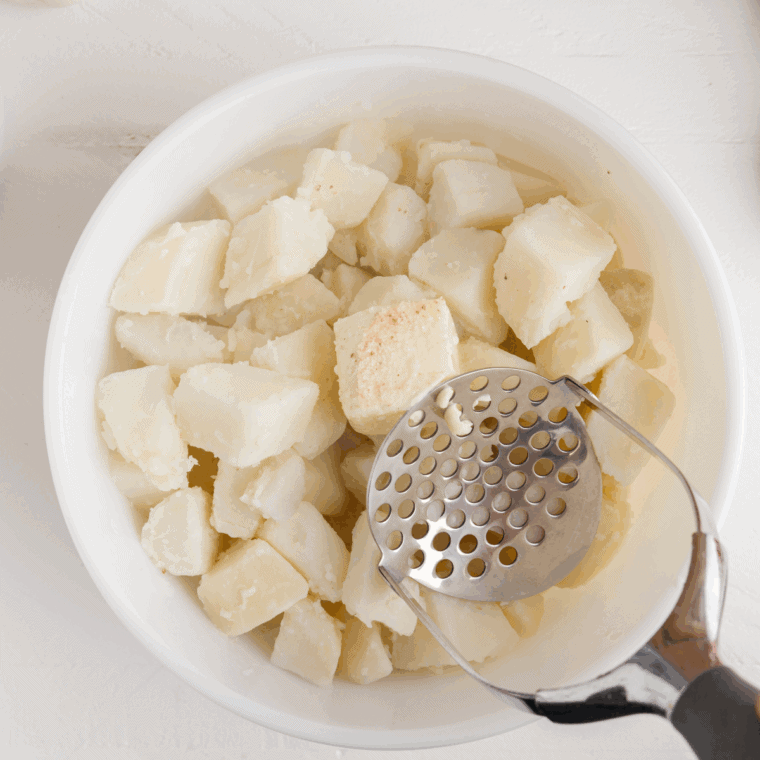 Drained boiled potatoes returned to the empty pot on the stove to evaporate moisture.