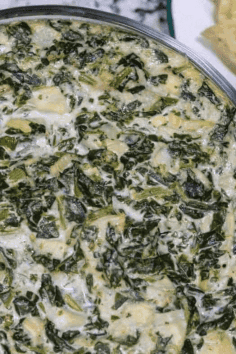 Creamy, cheesy creamed spinach in a white serving dish, restaurant-style.