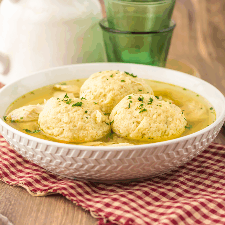Bowl of traditional Slow Cooker Matzo Ball Soup with fluffy matzo balls, shredded chicken, and fresh dill.