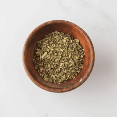 Jar of homemade spaghetti seasoning made with mixed dried herbs and spices.