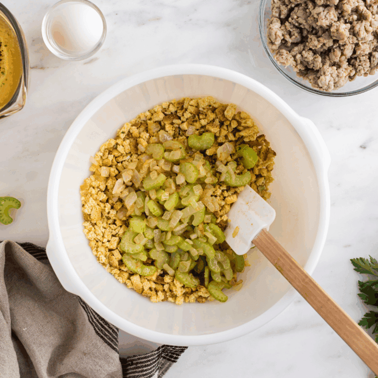 Sautéed onions, celery, and garlic cooking in a skillet.