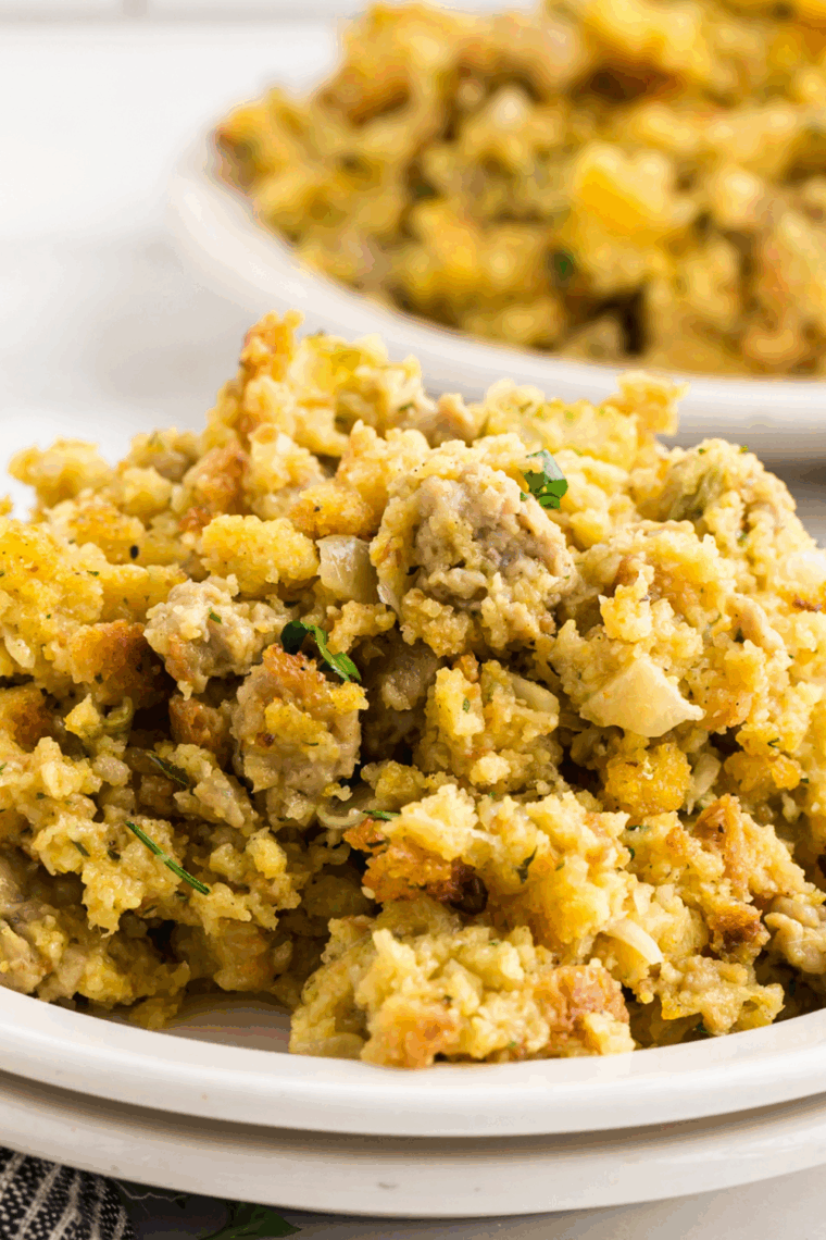 Baked Ina Garten cornbread stuffing with golden top and herbs in casserole dish