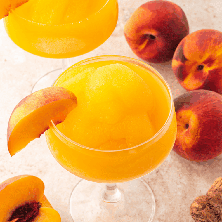 Frozen Peach Bellini slushi in a glass, garnished and ready to serve, made using a Ninja Slushi.