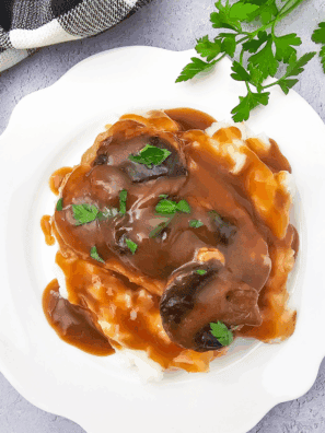 Homemade Texas Roadhouse brown gravy served in a small bowl with a spoon.