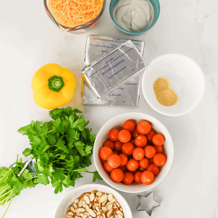 Ingredients needed for Christmas Tree Cheese Ball Appetizer on kitchen table.